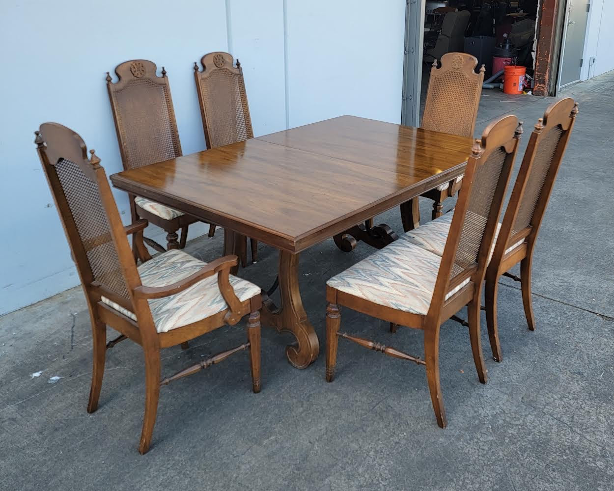Dark wood dining table with 6 wicker/cane/ rattan high back chairs and 3 leaves