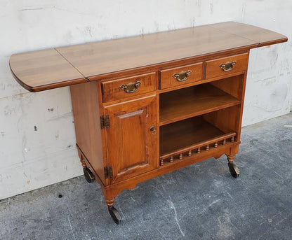 Dark wood kitchen buffet cabinet on wheels with drop side leaves
